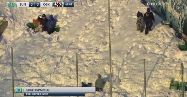Zweedse fans glijden tijdens de wedstrijd over ondergesneeuwde tribunes